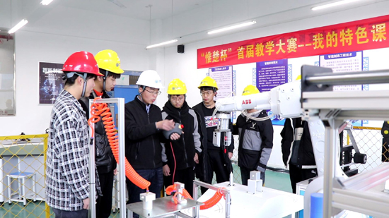 王建華老師指導(dǎo)學(xué)生操作機(jī)器人.jpg